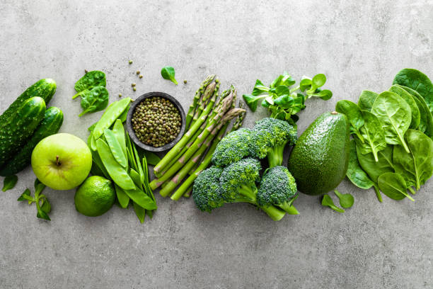 Healthy vegetarian food concept background, fresh green food selection for detox diet, raw broccoli, apple, cucumber, spinach, peas, asparagus, avocado, lime, corn salad and mung bean, view from above, flat lay fondo de concepto de alimentos vegetarianos saludables, selección de alimentos verdes frescos para la dieta detox, brócoli crudo, manzana, pepino, espinaca, guisantes, espárragos, aguacate, lima, ensalada de maíz y frijol mung, vista desde arriba, lay