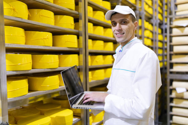 istock worker with a laptop in his hands at the cheese warehouse 1133394749