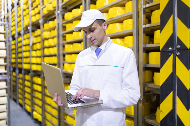 istock worker with a laptop in his hands at the cheese warehouse 1133394751