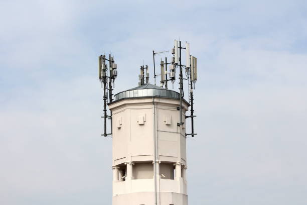 istock Top of large concrete industrial complex tower with multiple cell phone antennas and transmitters surrounded with security cameras 1133396304