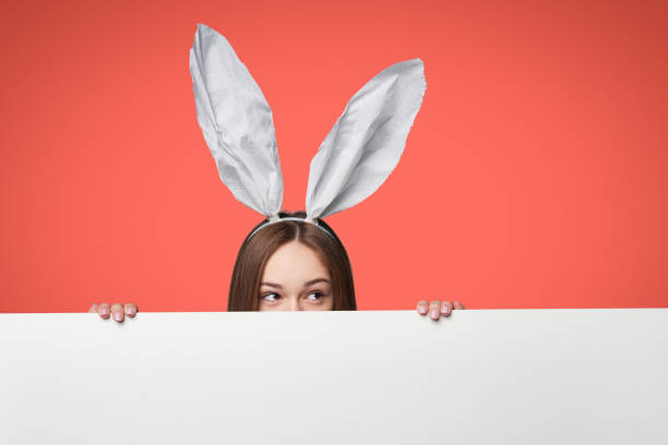 istock Girl wearing bunny ears holding a banner 1133397792