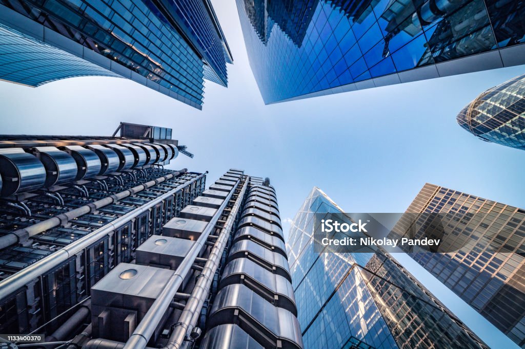 Looking directly up at the skyline of the financial district in central London - stock image Highly detailed abstract wide angle view up towards the sky in the financial district of London City and its ultra modern contemporary buildings with unique architecture. Shot on Canon EOS R full frame with 14mm wide angle lens. Image is ideal for background. London - England Stock Photo