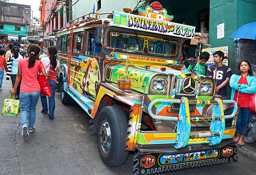 Baguio City, Benguet Province, Philippines - May 5, 2012: Front low-angle view of colorful jeepneys parking at a steep street in downtown area