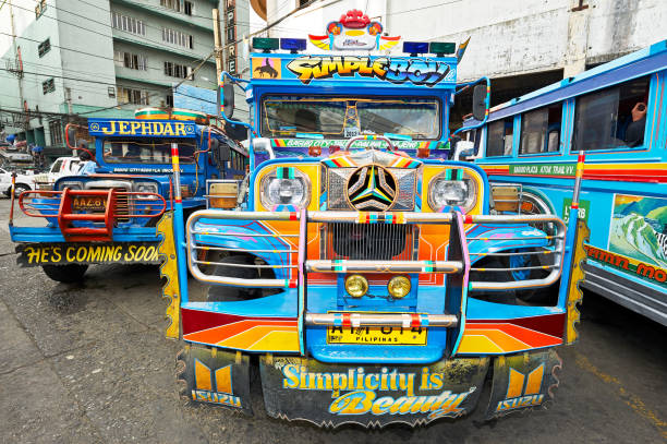 Manila, Philippines - August 25, 2019: Colorful jeepney parked along a bustling street in Manila, showcasing local transportation culture on a rainy afternoon