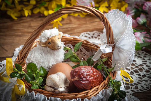 Traditional Easter basket with food on the wooden table.