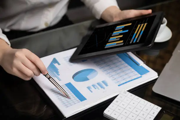 Photo of Close-up of hand holding tablet and point pen at chart