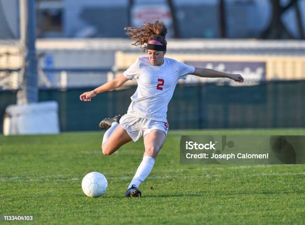 Chica Atlética Joven Jugando Con Una Pelota De Fútbol En Un Campo De Césped Verde Foto de stock y más banco de imágenes de Fútbol