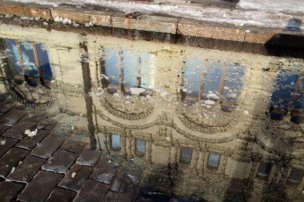 istock Reflection of a building in a puddle on a cobblestone pavement 1133404123