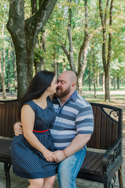 istock Two people in love sit on a bench in the park 1133404334