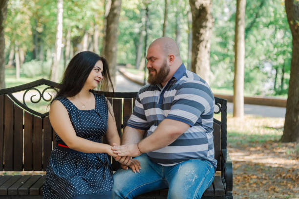 istock Two people in love sit on a bench in the park 1133404456