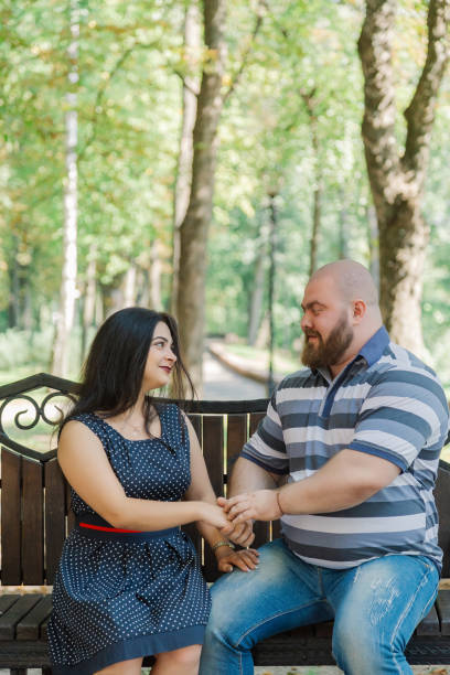 istock Two people in love sit on a bench in the park 1133404501