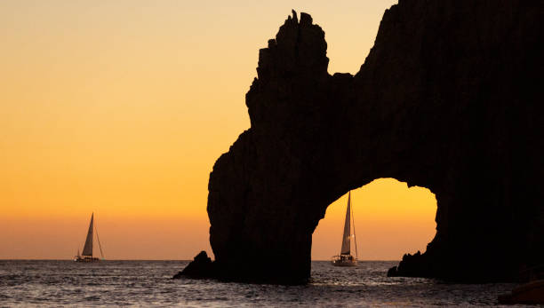 Sailboat in Los Cabos Arch Sailboats through the Arch of Los Cabos viewed from boat cabo san lucas stock pictures, royalty-free photos & images