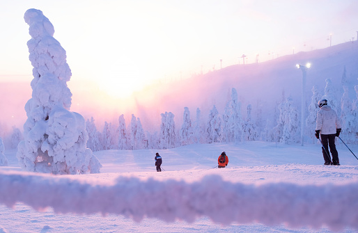 Group of skiers down the mountain. The ski resort of Ruka Kuusamo. Morning on the mountain. Finland Lapland.