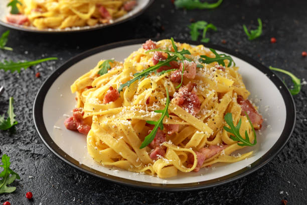 istock Classic Carbonara pasta, spaghetti with pancetta, bacon, egg, parmesan cheese and green arugula. 1133407438