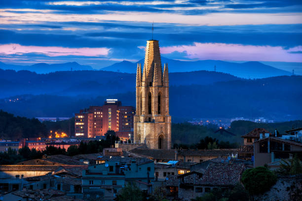 Illuminated bell tower of the Sant Feliu Basilica at dusk in city of Girona in Catalonia, Spain.