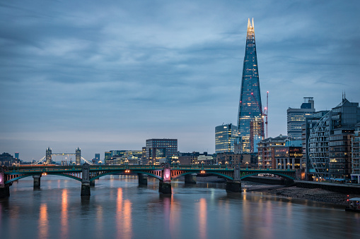 London's skyline in the morning as viewed from the Millennium bridge, including: The Shard, London Bridge 1, Tower bridge on the Thames river. Shot on Canon EOS R full frame system.