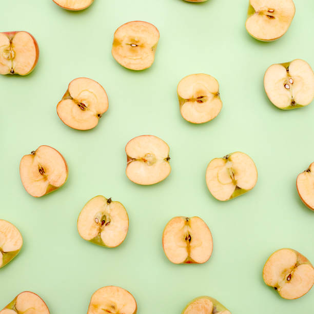 istock Background of cut in half apples on green background 1133413110