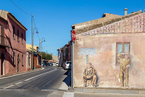 Sardinia Italy on December 27, 2019: Murals painted on houses in the streets of Tinnura depicting moments of rural and village life