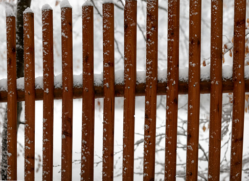 Wooden fence while heavy snow fall
