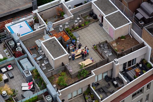 Downtown Vancouver, British Columbia, Canada - June 22, 2018: Aerial view from above of people enjoying a summer evening on top of the roof.