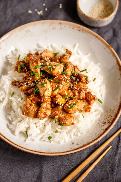 istock Top view on sesame chicken pieces with rice on a ceramic plate. Chinese traditional dish. 1133426305