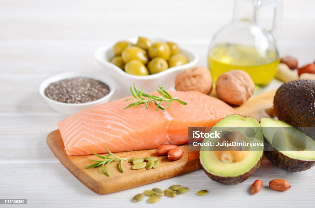 Selection of healthy unsaturated fats, omega 3 - fish, avocado, olives, nuts and seeds. Selection of healthy unsaturated fats, omega 3 - fish, avocado, olives, nuts and seeds, selective focus. Fat - Nutrient Stock Photo