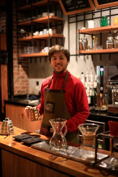 istock Young man barista at work in a cafe. Preparing pour over coffee 1133429340