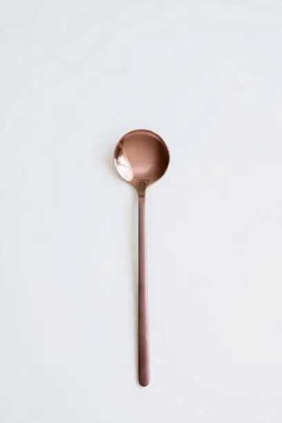 New spoons of copper color. On white isolated background. Cutlery.