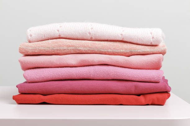 istock On a pink dresser is a stack of folded clothes. Gray background. Close-up 1133429520