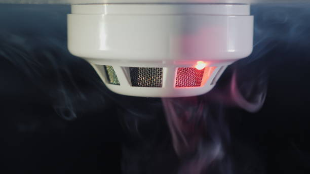 Close-up shot: The smoke detector is triggered by a trickle of dum, the red indicator lights up stock photo
