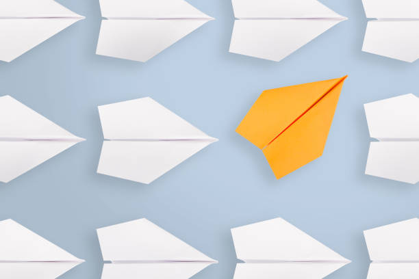 istock Change concepts with orange paper airplane leading among white 1133436060