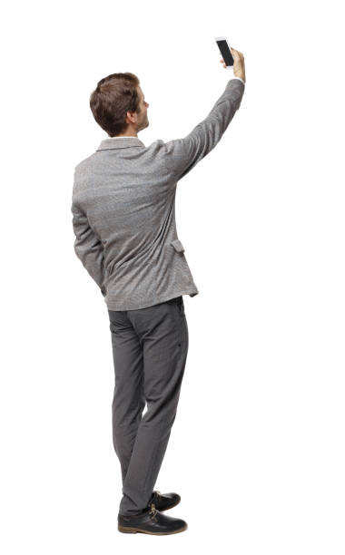 istock Back view of a businessman in a suit making a selfie. 1133438058