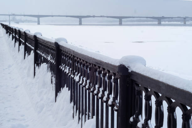 istock frozen river, quay fence and road bridge away 1133438620