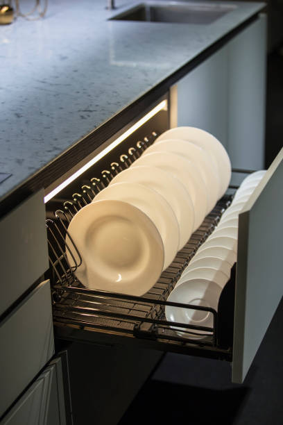 Modern kitchen, storage space for plates, illuminated drawer in luxury kitchen