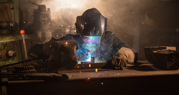 istock Welder is welding metal part in factory 1133443982