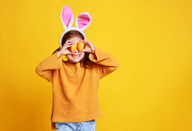 黄色のイースターエッグとおかしい幸せな子供の女の子 - easter egg easter yellow paint ストックフォトと画像