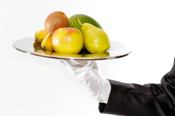 Waiter brings and presents fresh fruit