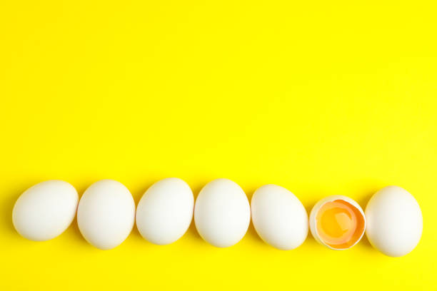 istock Chicken eggs with half yolk on color background, space for text 1133447105