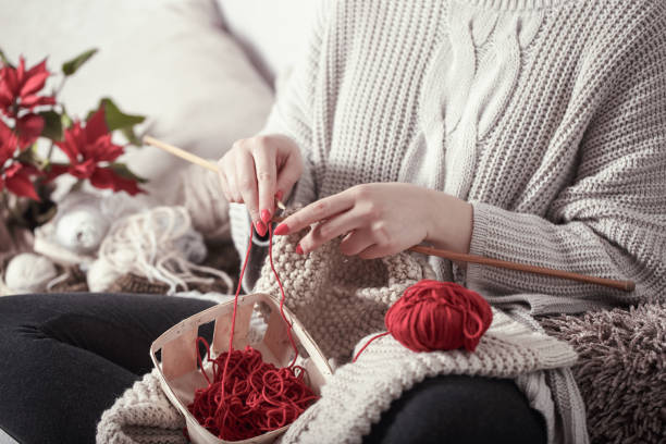 istock woman knits knitting needles on the couch 1133449794
