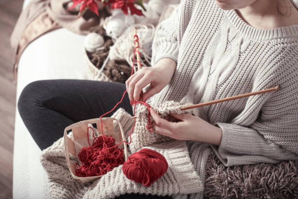 istock woman knits knitting needles on the couch 1133449799