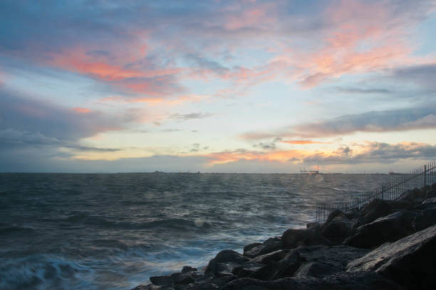 drammatica onda oceanica schizzo la sera con cielo crepuscolare in inverno al breakwater al molo di st kilda a melbourne in australia - melb foto e immagini stock