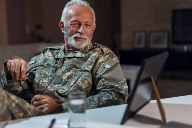 istock Mature army soldier recalling the memories while looking at framed picture. 1133454253