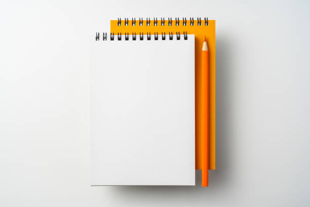 istock two spiral orange notebook and pen on white 1133454587