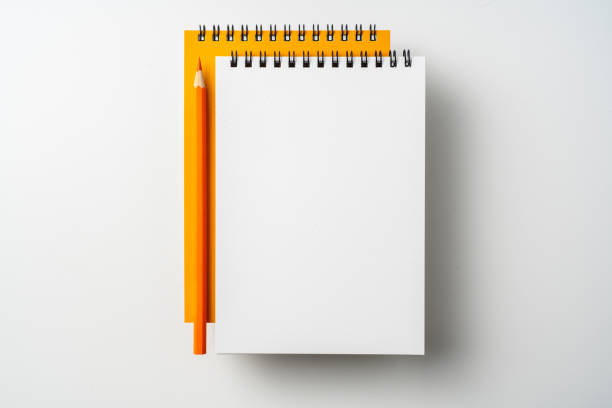 istock two spiral orange notebook and pen on white 1133454595