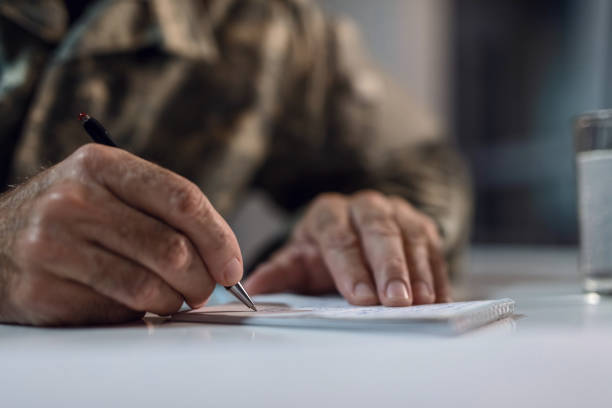 Close up of senior soldier taking notes. Close up of mature army soldier writing a letter. national guard stock pictures, royalty-free photos & images