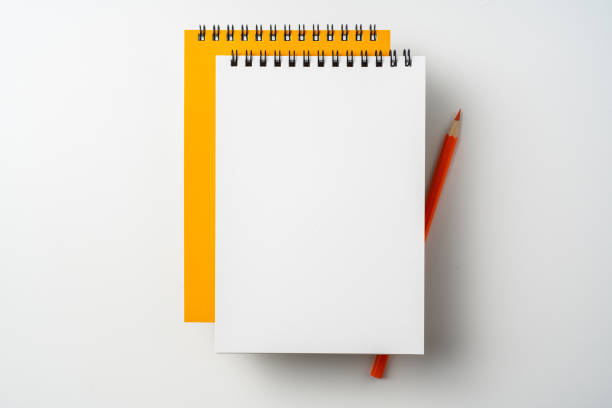 istock two spiral orange notebook and pen on white 1133454613