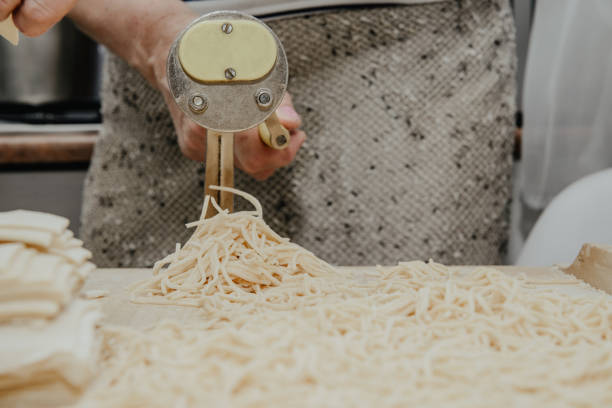 istock Making pasta from the dough. A woman is making pasta noodles using a pasta machine. 1133458587