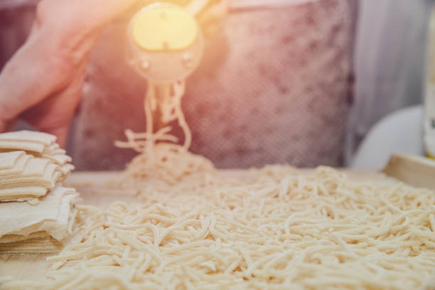 istock Making pasta from the dough. A woman is making pasta noodles using a pasta machine. 1133458622