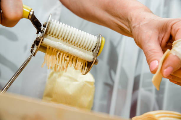 istock Making pasta from the dough. A woman is making pasta noodles using a pasta machine. 1133458654