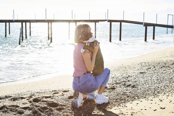 istock Women and Dog at the Beach 1133463447